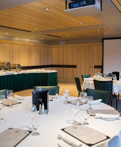 St. Andrews logo set up with table settings and a projector screen