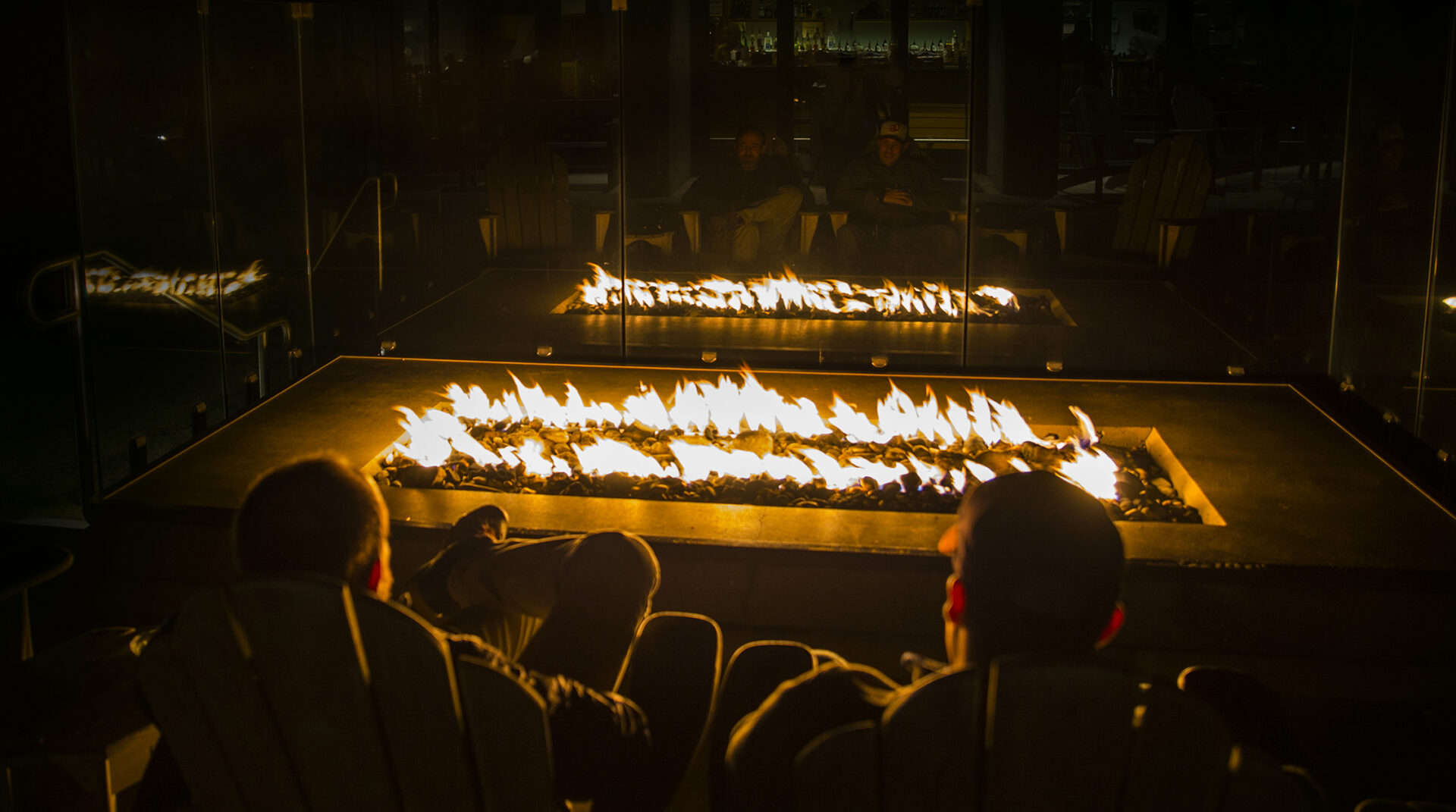 Two men sitting next to the outdoor fireplace